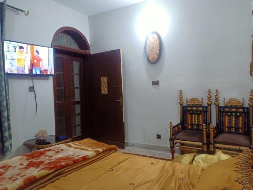 una camera con un letto e un orologio a muro di Room with Separate Entrance & Parking & Fast Wifi a Islamabad