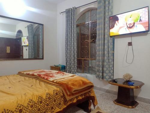 a bedroom with a bed and a tv on the wall at Room with Separate Entrance & Parking & Fast Wifi in Islamabad