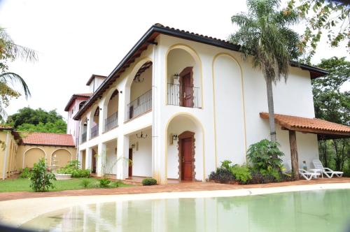 a house with a swimming pool in front of it at El Pueblito Iguazú in Puerto Iguazú