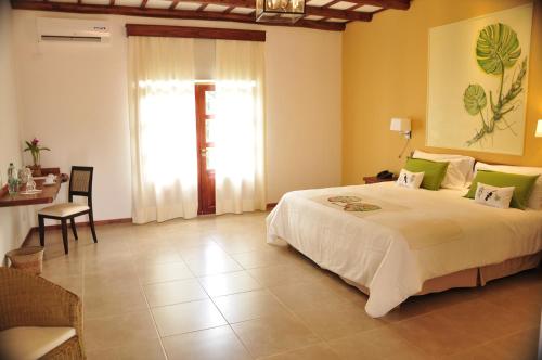 a bedroom with a large white bed and a table at El Pueblito Iguazú in Puerto Iguazú