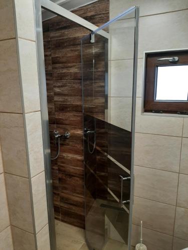 La salle de bains est pourvue d'une douche avec une porte en verre. dans l'établissement Domek w sercu lasu w Borach Tucholskich, à Ocypel