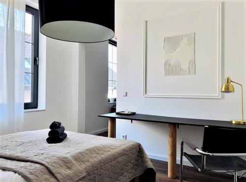 a bedroom with a bed and a desk and a chair at Gallery Room 02 in Bielefeld