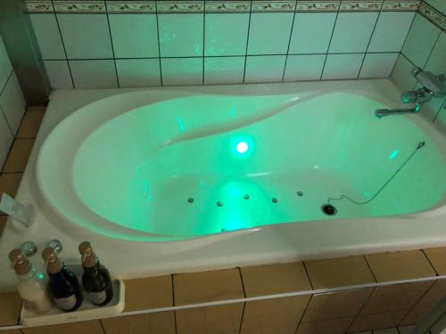a bath tub with a green light in it at HOTEL MINT HOUSE -resort and relaxation- in Mihama