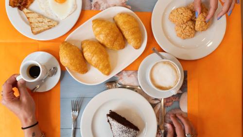 a table with plates of food and a cup of coffee at B&B Hotel Villa Nora in Bellaria-Igea Marina