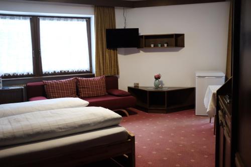 カンポ・トゥーレスにあるGarni Trojerのベッドとソファ付きのホテルルーム
