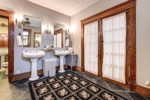 a bathroom with two sinks and a mirror at Roomy Vacation Rental in Downtown Fort Wayne! in Fort Wayne