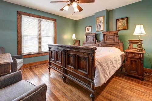 a bedroom with a wooden bed and a couch at Roomy Vacation Rental in Downtown Fort Wayne! in Fort Wayne