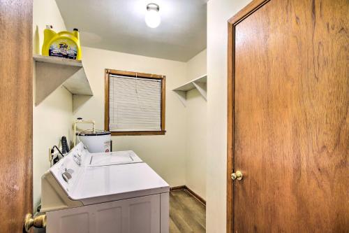a bathroom with a white sink and a wooden door at Charming Aiken Vacation Rental 2 Mi to Dtwn! in Aiken