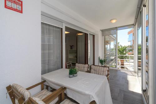 a dining room with a white table and chairs at UHC Alexis Family Apartments in Salou