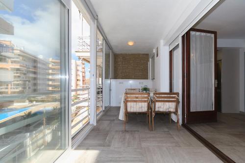 Habitación con mesa y puerta de cristal en UHC Alexis Family Apartments, en Salou