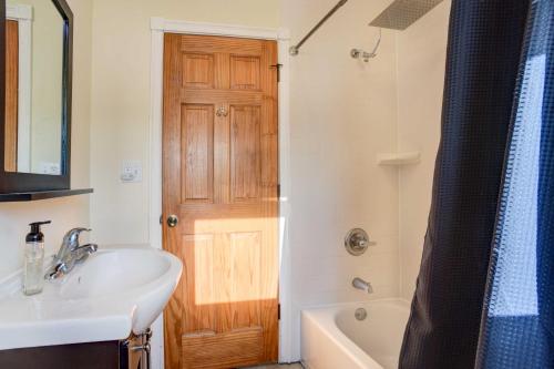 ein Badezimmer mit einem Waschbecken und einer Holztür in der Unterkunft Cozy Waterford Apartment with Waterfront Views! in Waterford