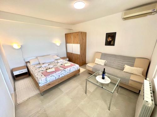 a small bedroom with a bed and a couch at Apartments Kate in Dramalj