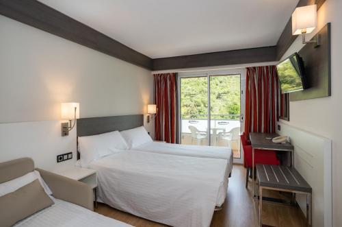 a hotel room with two beds and a window at Medplaya Hotel Santa Monica in Calella