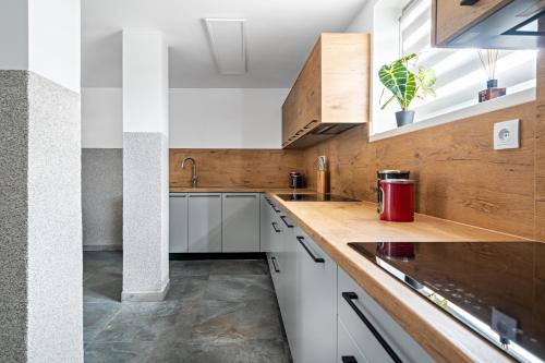 a kitchen with white cabinets and a wooden counter top at Noclegi Krańcowa in Zgorzelec