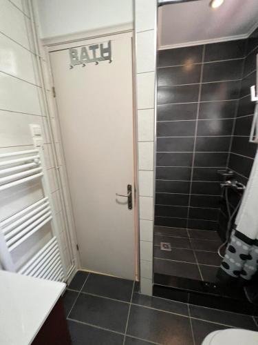 a bathroom with a white door and a toilet at Avli Cottage in Sami