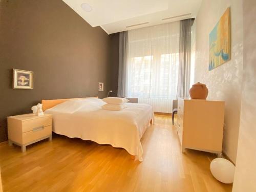 a bedroom with a large white bed and a window at Modern apartment,24/7 security,free parking in Belgrade