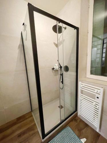 a shower with a glass door in a bathroom at Cosy appartement hyper centre in Saint-Germain-en-Laye