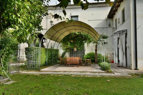 an archway with a table and chairs in a yard at Villa Navagero - Ca' Degli Stefani A in Rovarè