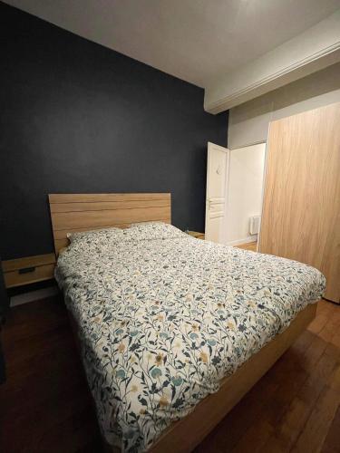 une chambre avec un lit avec un couvre-lit fleuri dans l'établissement Cosy appartement hyper centre, à Saint-Germain-en-Laye