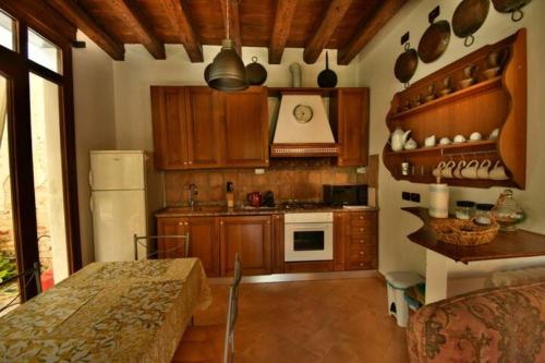 a kitchen with wooden cabinets and a white refrigerator at Villa Navagero - Ca' Degli Stefani A in Rovarè