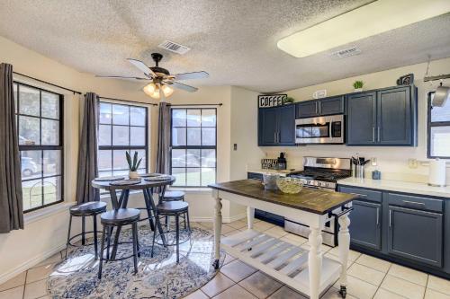 a kitchen with black cabinets and a table with stools at 4 Mi to Joe Pool Lake Home in Grand Prairie in Grand Prairie