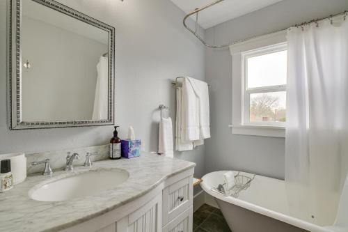 a white bathroom with a tub and a sink at Charming Tacoma Vacation Home with Fenced Yard in Tacoma