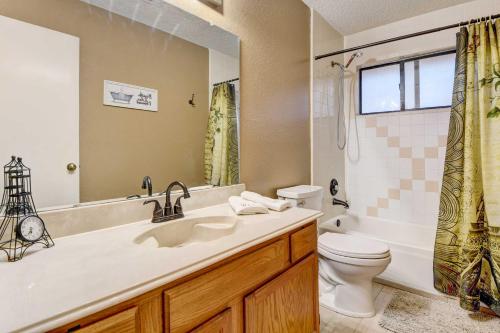 een badkamer met een wastafel, een toilet en een spiegel bij Grand Prairie Home, 4 Mi to Joe Pool Lake! in Grand Prairie