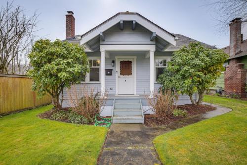 a white house with trees in the yard at Charming Tacoma Vacation Home with Fenced Yard in Tacoma