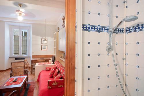 a living room with a red couch and a shower at Monolocale Daneri 72 in Bonassola