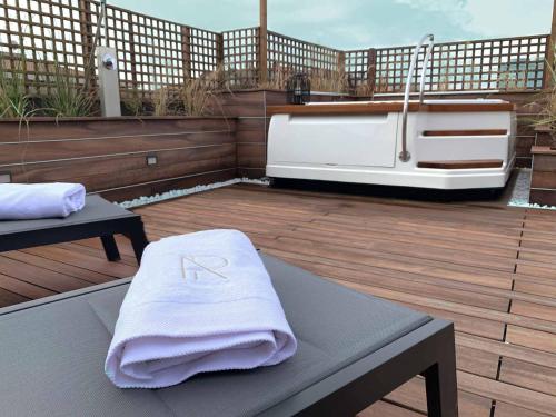 - une serviette assise au-dessus d'une terrasse avec un bain à remous dans l'établissement AR Prestige Penthouse - Soho, à Bergame