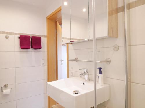 ein weißes Bad mit einem Waschbecken und einer Dusche in der Unterkunft Ferienwohnung Am Eiberg in Bad Wildbad
