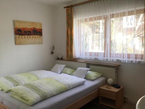 a bed sitting in a bedroom with a window at Ferienwohnung Am Eiberg in Bad Wildbad