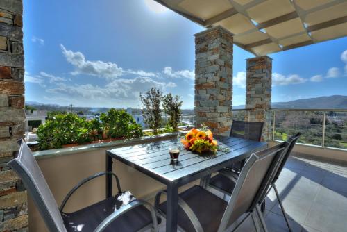 a table and chairs on a balcony with a view at Vardians Villas & Suites in Karistos