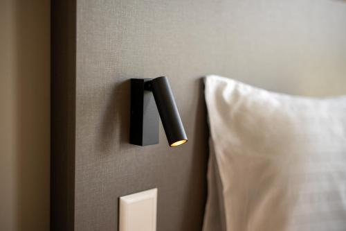 a black light on a wall next to a bed at b-smart motel Schaan in Schaan