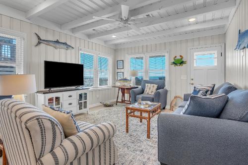 a living room with two couches and a flat screen tv at Lowe Tide by Oak Island Accommodations in Oak Island