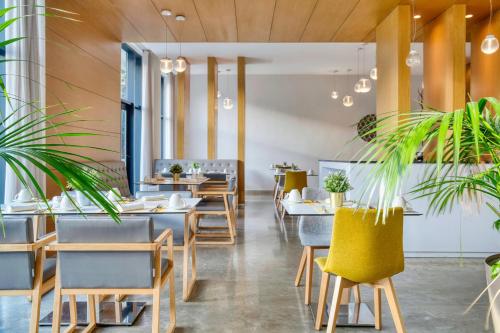 un restaurant avec des tables, des chaises et des plantes en pot dans l'établissement Vichy Thermalia Spa Hôtel, à Fès