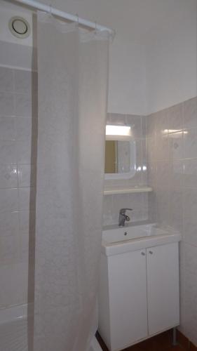 une salle de bain blanche avec un lavabo et une douche dans l'établissement Coquet Studio Cabine, Les Balcons de la Méditerranée, Narbonne Plage, à Narbonne-Plage