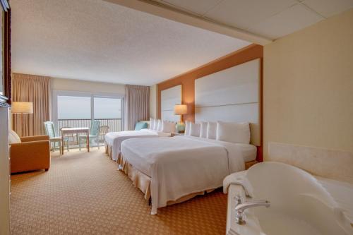 a hotel room with two beds and a bathroom at Grand Hotel Ocean City Oceanfront in Ocean City