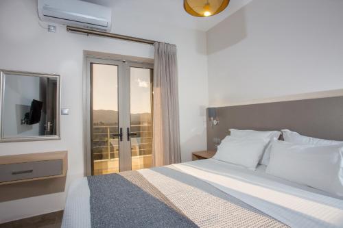 - une chambre avec un lit, une fenêtre et une télévision dans l'établissement Vardians Villas & Suites, à Karistos