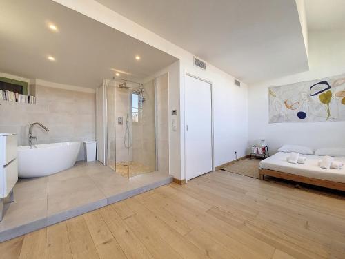 ein Bad mit einer Badewanne und einer Dusche sowie ein Bett in der Unterkunft Nestor&Jeeves - NICE TO MEET YOU - Central - Top floor in Nizza