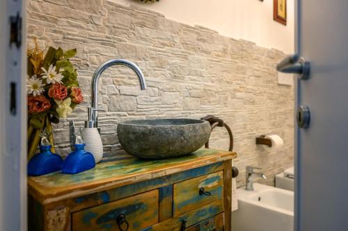 a bathroom with a sink and a stone wall at Villa Marino in San Baronto