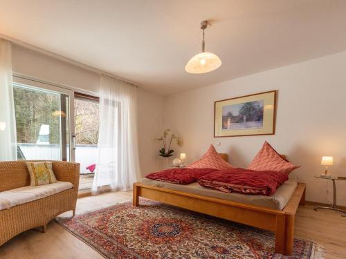 1 dormitorio con cama, sofá y ventana en Ferienwohnung in Triberg am Waldrand - idyllisch, ruhig, erholsam, en Triberg