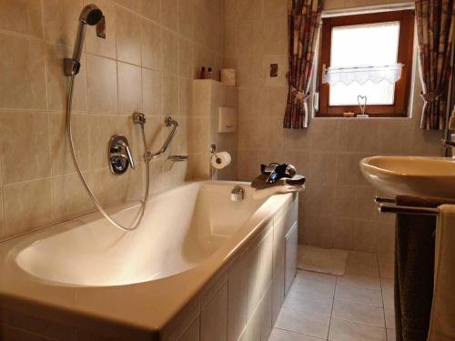 een badkamer met een bad en een wastafel bij Ferienhaus am Bach in Riedenburg