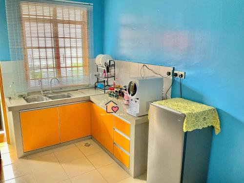 a kitchen with orange and blue walls and a sewing machine at WIRA HOMESTAY KUANTAN in Kuantan