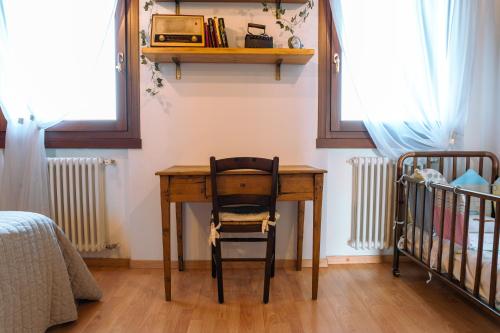 a wooden desk with a chair next to a crib at Venice's neighbor Home in Mirano