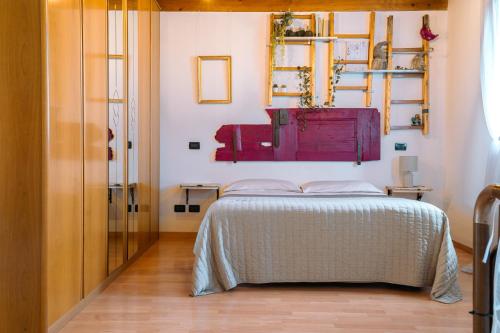 1 dormitorio con 1 cama y una pintura en la pared en Venice's neighbour Home, en Mirano
