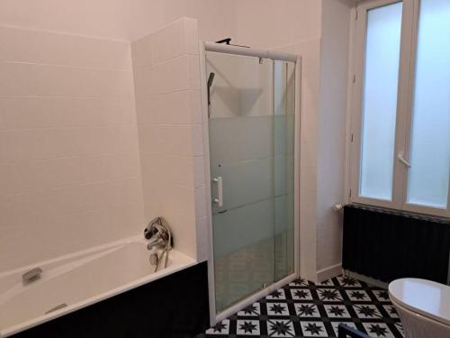 une douche avec une porte vitrée dans une salle de bain dans l'établissement La Buissonnière Maison Authentique Au Cœur du Village, à Cadouin