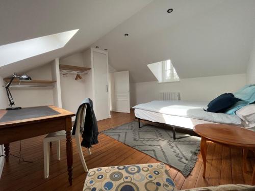 a bedroom with a bed and a desk and a piano at Sur les toits de Fontainebleau - Hypercentre in Fontainebleau