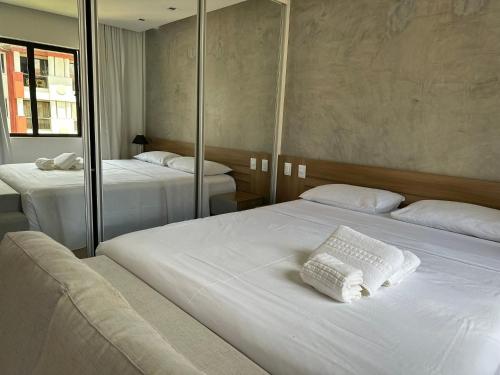 Habitación de hotel con 2 camas y espejo en Luxuoso Flat Lake Side com vista para o lago, en Brasilia