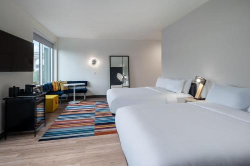 a hotel room with two beds and a flat screen tv at Aloft Austin South in Austin